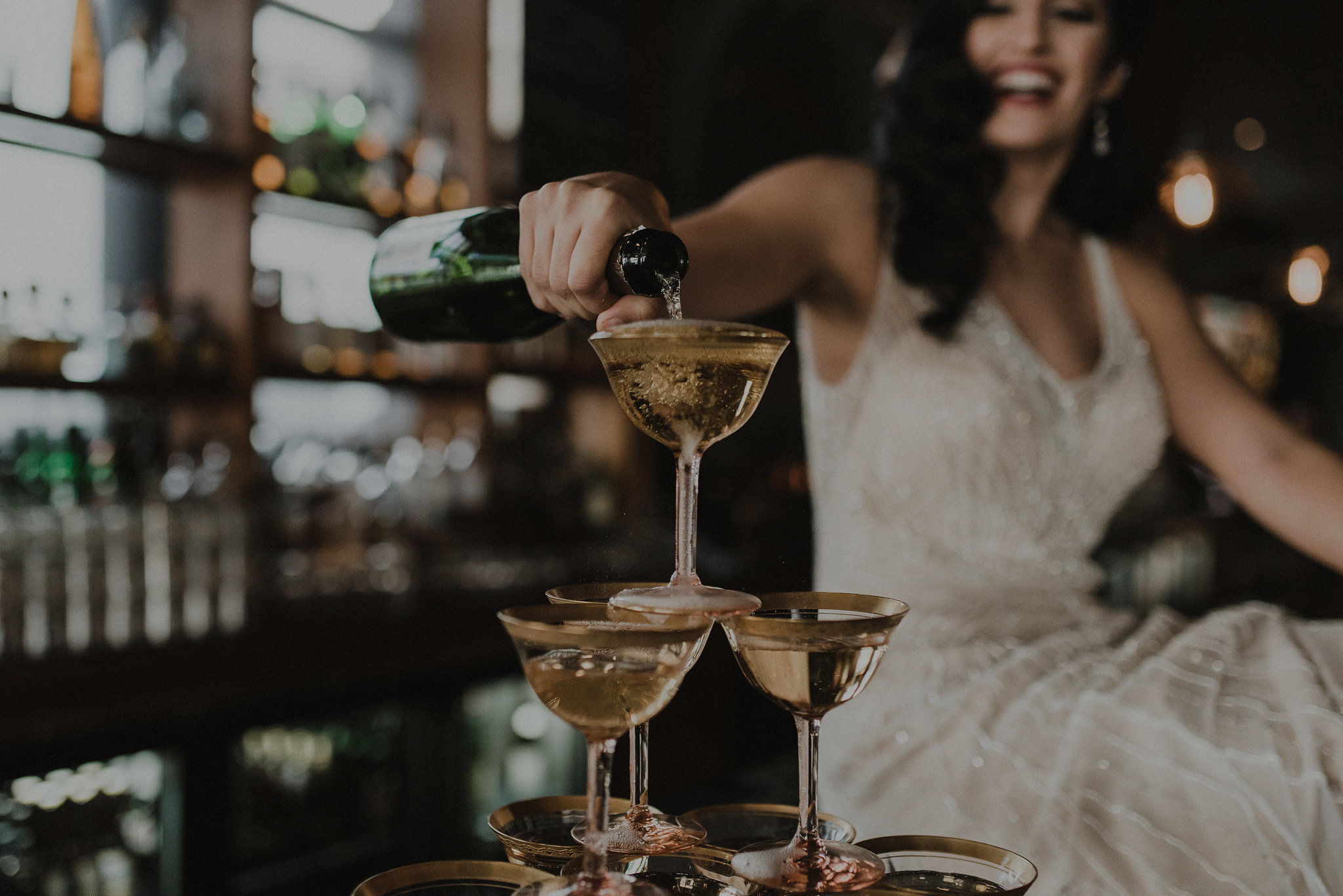 Woman pouring bottle of champagne in glass